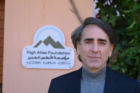 Dr. Yossef Ben-Meir wearing blue sweater and blazer with tan background